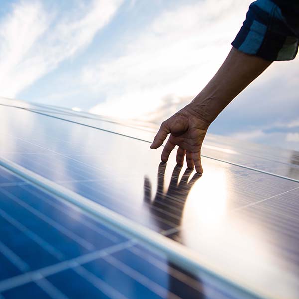 person touching solar panels